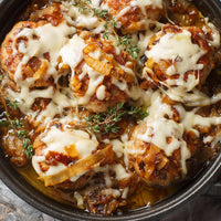 Baked chicken with cheese and herbs in a dish