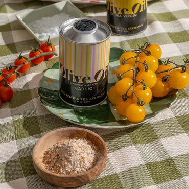 Garlic Olive Oil on plate next to sea salt and yellow tomatoes