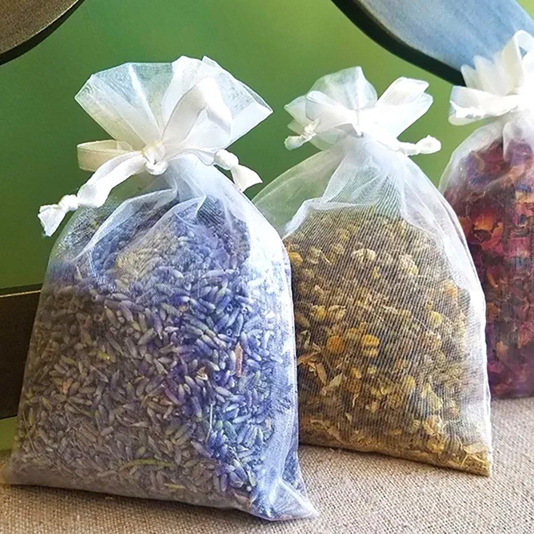 Dried lavender flowers, chamomile flowers, and rose petals, in white sachets.